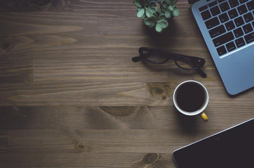 Table with a notebook, coffee and glasses